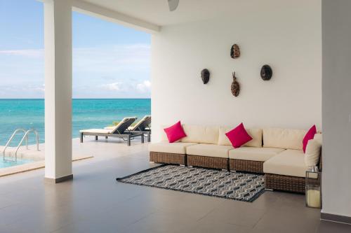 南威Safira Blu Luxury Resort & Villas的带沙发的客厅,享有海景