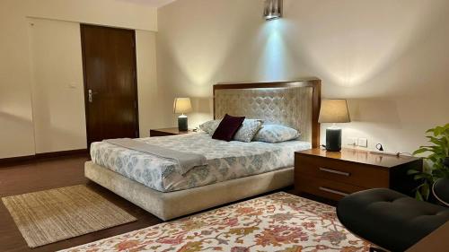 班加罗尔LUHO Grande的一间卧室配有一张大床、一个梳妆台和台灯。