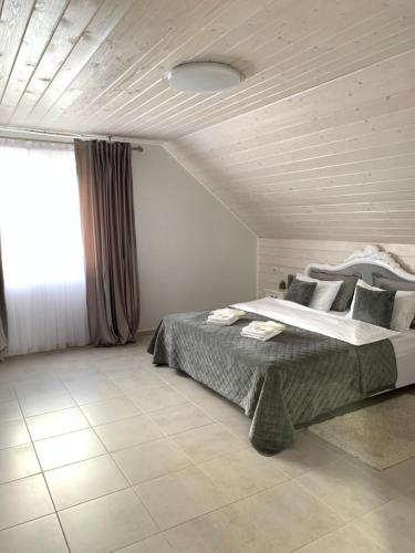 ZbarazhCafé Chalet Edelweiss Holiday Home的一间卧室设有一张大床和一个窗户。