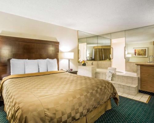 贝克斯菲尔德California Inn and Suites Bakersfield的酒店客房配有一张床和浴缸。