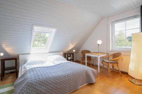 格洛米茨Sur la mer的一间卧室配有一张床、一张桌子和两个窗户