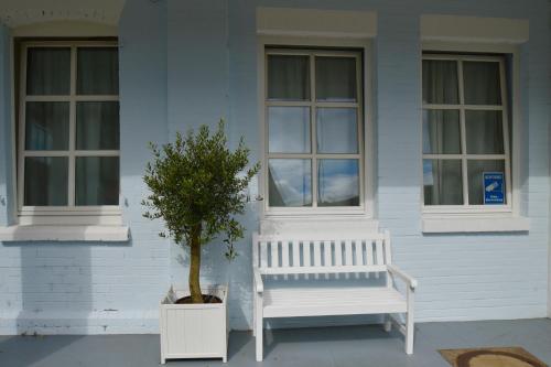 杜塞尔多夫哈姆酒店的屋前的白色长凳和一棵树
