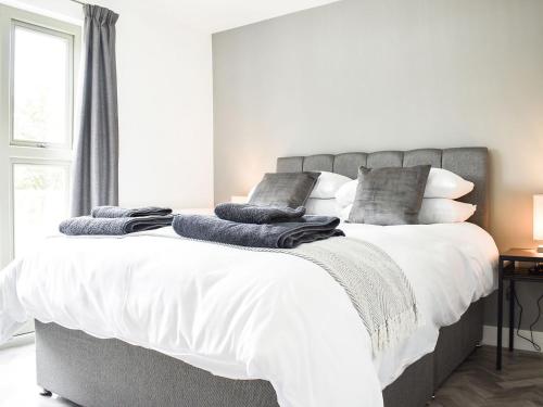 温厄姆Deerson Barn的卧室配有一张带白色床单和枕头的大床。