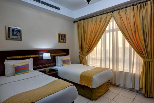 沙迦奥哈亚特公寓酒店的酒店客房设有两张床和窗户。
