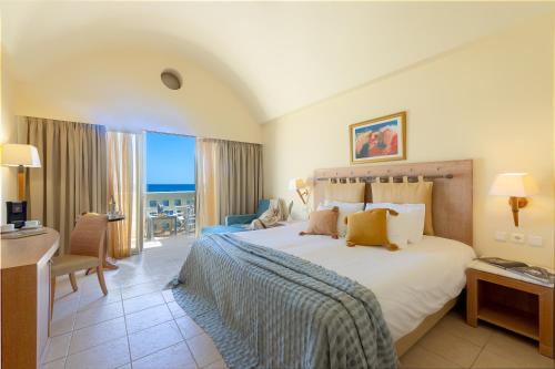 埃亚玛琳娜奈奇多Giannoulis - Santa Marina Plaza (Adults Only)的酒店客房设有一张大床和一张书桌。
