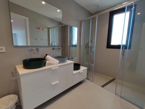 比纳罗斯VILLA EULALIA的一间带两个水槽和玻璃淋浴间的浴室