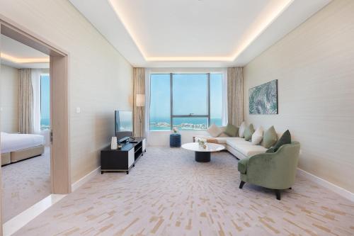 迪拜Luxury Living & Views -St Regis High Floor Suite 4 by Exclusive Holiday Homes的带沙发、床和电视的客厅