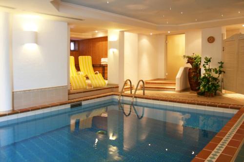 里茨勒恩阿潘松尼酒店的游泳池,在酒店的房间里摆放着黄色椅子