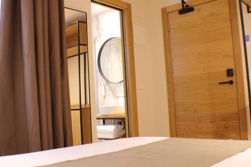 安道尔城梅非尼酒店的一间带木门和镜子的卧室