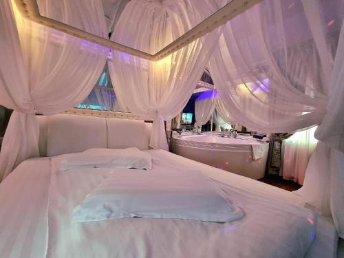布拉索夫Anadi Hotel Boutique的卧室配有带窗帘的白色床和浴缸