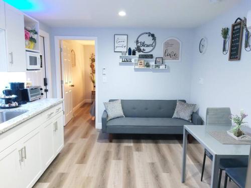 坦帕Torres Tiny Home Midtown WestTampa RJS的一间带蓝色沙发的客厅和一间厨房