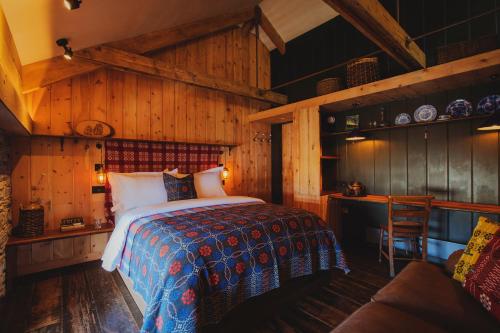 卡迪根Albion Aberteifi的卧室配有一张床铺,位于带木墙的房间内