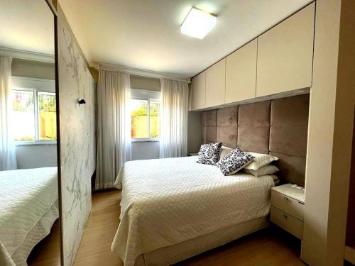 帕苏丰杜Apartamento Villa Nova Master Collection的一间卧室设有两张床和两个窗户。