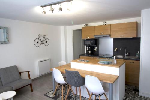 拉弗洛特Cosy Apartment In The Center Of La Flotte的厨房以及带桌椅的起居室。
