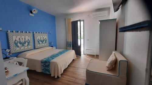 波萨达Hotel Made的卧室拥有蓝色的墙壁,配有一张床和椅子