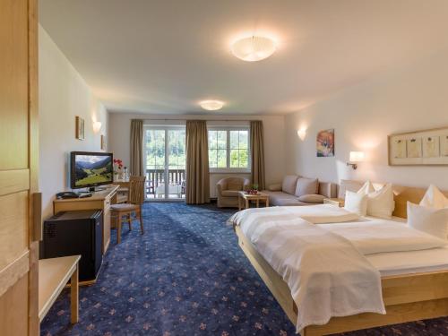 布里克森谷地霍普夫加尔滕玛格雷特乡村酒店的酒店客房设有一张大床和一台电视。