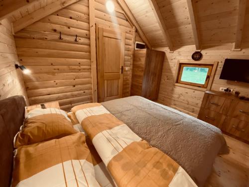 科拉欣Wooden Corner的小木屋内的卧室配有1张床和电视