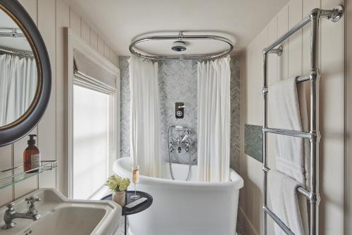 考斯Harold House的带浴缸、水槽和镜子的浴室