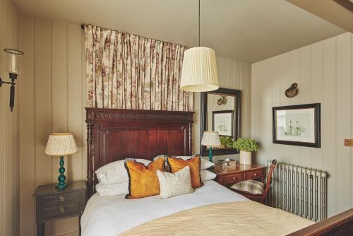考斯Harold House的一间卧室配有一张带橙色枕头的大床