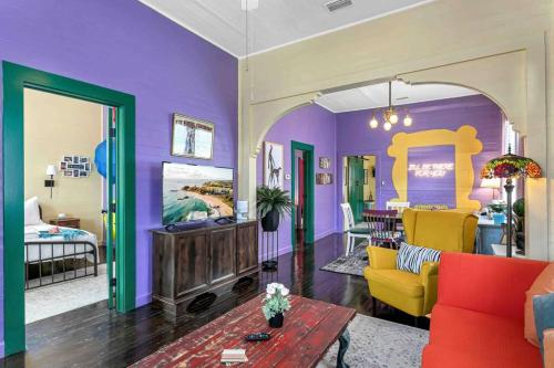 坦帕FRIENDS AIRBNB Themed 2bed 2bath walkable to all of Ybor的客厅设有紫色墙壁和黄色家具