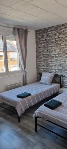 卡佩勒拉格朗德maison meublée 6 personnes的卧室设有2张床,设有砖墙