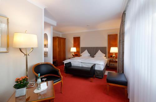 哥廷根格哈德罗曼蒂克酒店的酒店客房,配有一张床、一张桌子和椅子