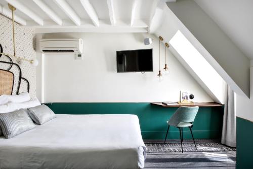 巴黎帕纳奇酒店的一间卧室配有一张床和一张书桌及电视
