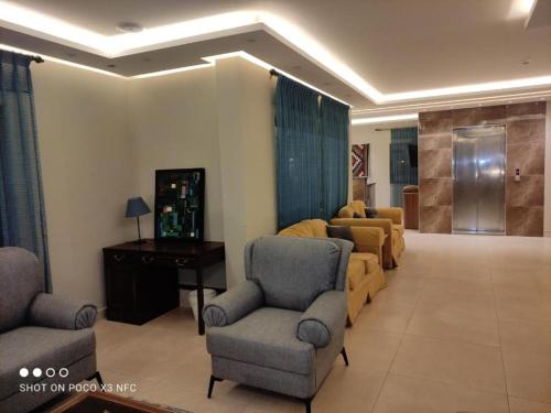 马达巴Black Iris Hotel II的客厅配有沙发、椅子和桌子