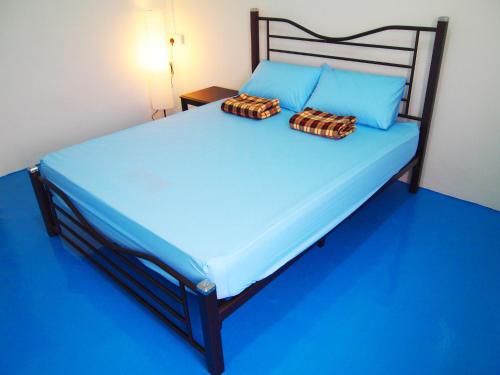 马六甲The Cardamom Hostel的一间卧室配有蓝色的床和两个枕头