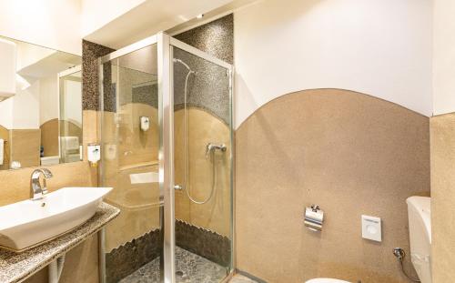 埃姆登库尔福厄斯特斯塔特长酒店的一间带水槽和淋浴的浴室