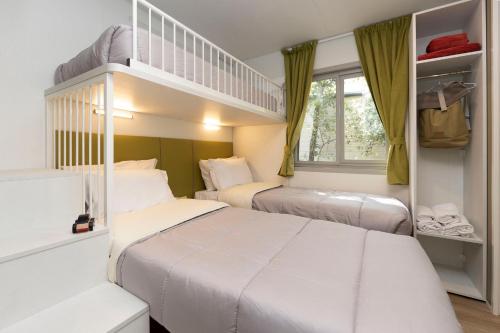 圣温琴佐hu Park Albatros Village的一间卧室配有两张床和一张双层床。