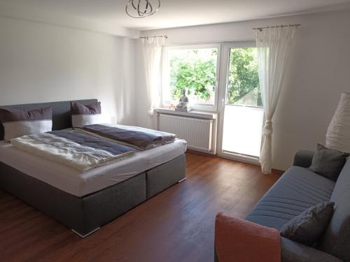 HildersHaus Luise Weber的一间卧室配有一张床、一张沙发和一个窗口