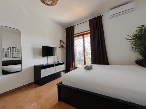罗马Appartamento di design的卧室配有一张白色大床和电视。
