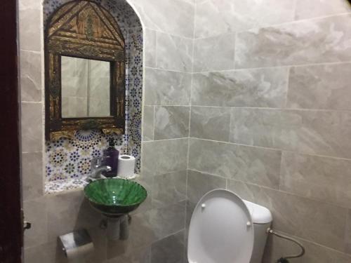 扎古拉卡里姆撒哈拉旅馆的一间带卫生间、水槽和镜子的浴室