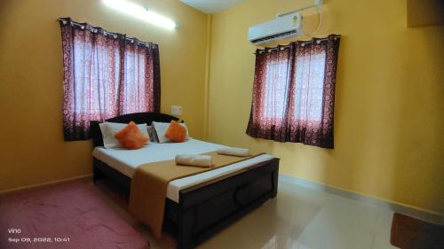 蒂鲁瓦纳马莱Aadhya guest house的一间卧室设有一张床和两个窗户。