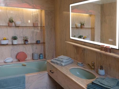 Saint-Martin-lez-TatinghemMille et une feuilles的浴室配有盥洗盆、镜子和浴缸
