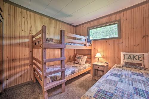 Comfy Burt Lake Abode - On-Site Lake Access!的一间卧室设有两张双层床和一扇窗户。