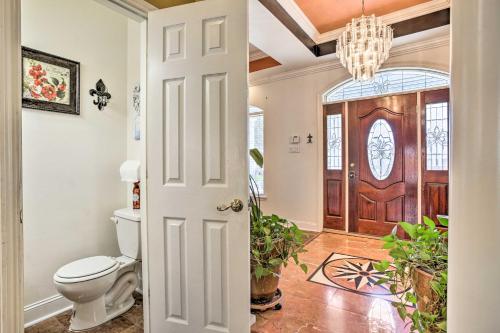 新奥尔良Welcoming New Orleans Home Near Bourbon St!的一间带卫生间的浴室和一扇带吊灯的门