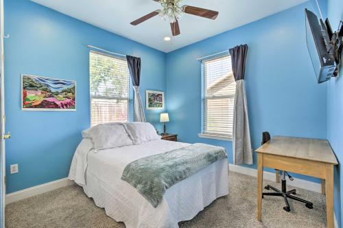 新奥尔良Welcoming New Orleans Home Near Bourbon St!的一间卧室设有蓝色的墙壁、一张床和一张书桌