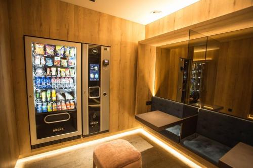 雷乌斯雷乌斯中心酒店的一间设有自动售货机和饮料冰箱的客房