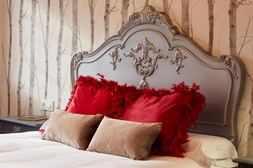 帕德隆Luxury Singular Villa Rosa的一张带红色枕头的大床头板的床
