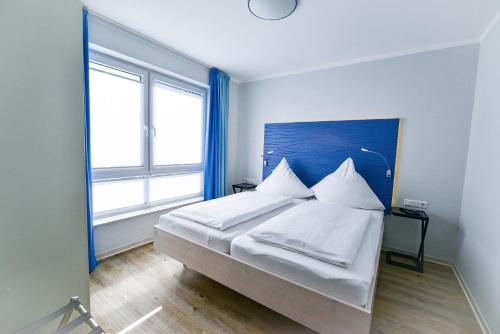 库克斯港Beach Lodge BL03的一间卧室配有带白色床单和枕头的床。