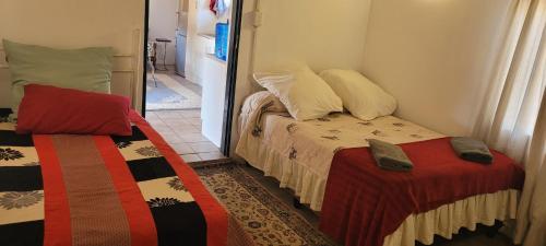 塔巴津比Vanross Self Catering Accommodation的小房间设有两张床和镜子