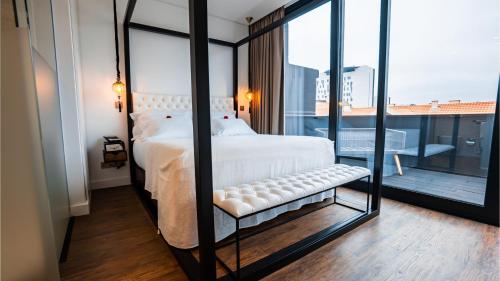 里斯本Hills Hotel Lisboa的卧室设有白色的床和大窗户