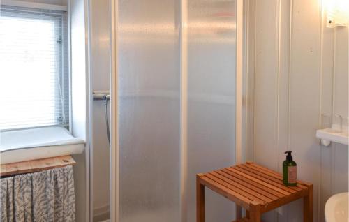 斯朱森Gorgeous Home In Sjusjen With Wifi的带淋浴的浴室以及带瓶子的桌子。