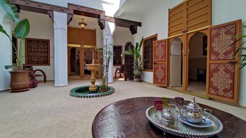 马拉喀什RIAD DAR En-Nawat的一间设有木桌的客房和一间设有