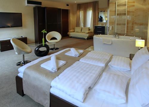 欧罗什哈佐布里尔奥罗索哈札酒店的酒店客房配有一张床和浴缸。