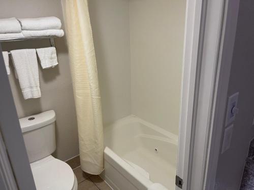 布兰森Stratford House Inn的浴室配有白色卫生间和浴缸。