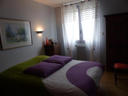 格朗维尔Résidence Saint-Nicolas Granville的一间卧室配有一张带紫色枕头的床