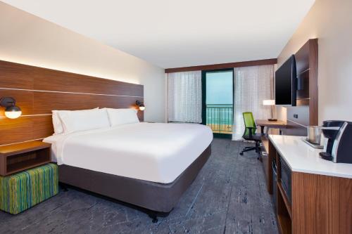 弗吉尼亚海滩弗吉尼亚海滩智选假日酒店的酒店客房设有一张大床和一张书桌。